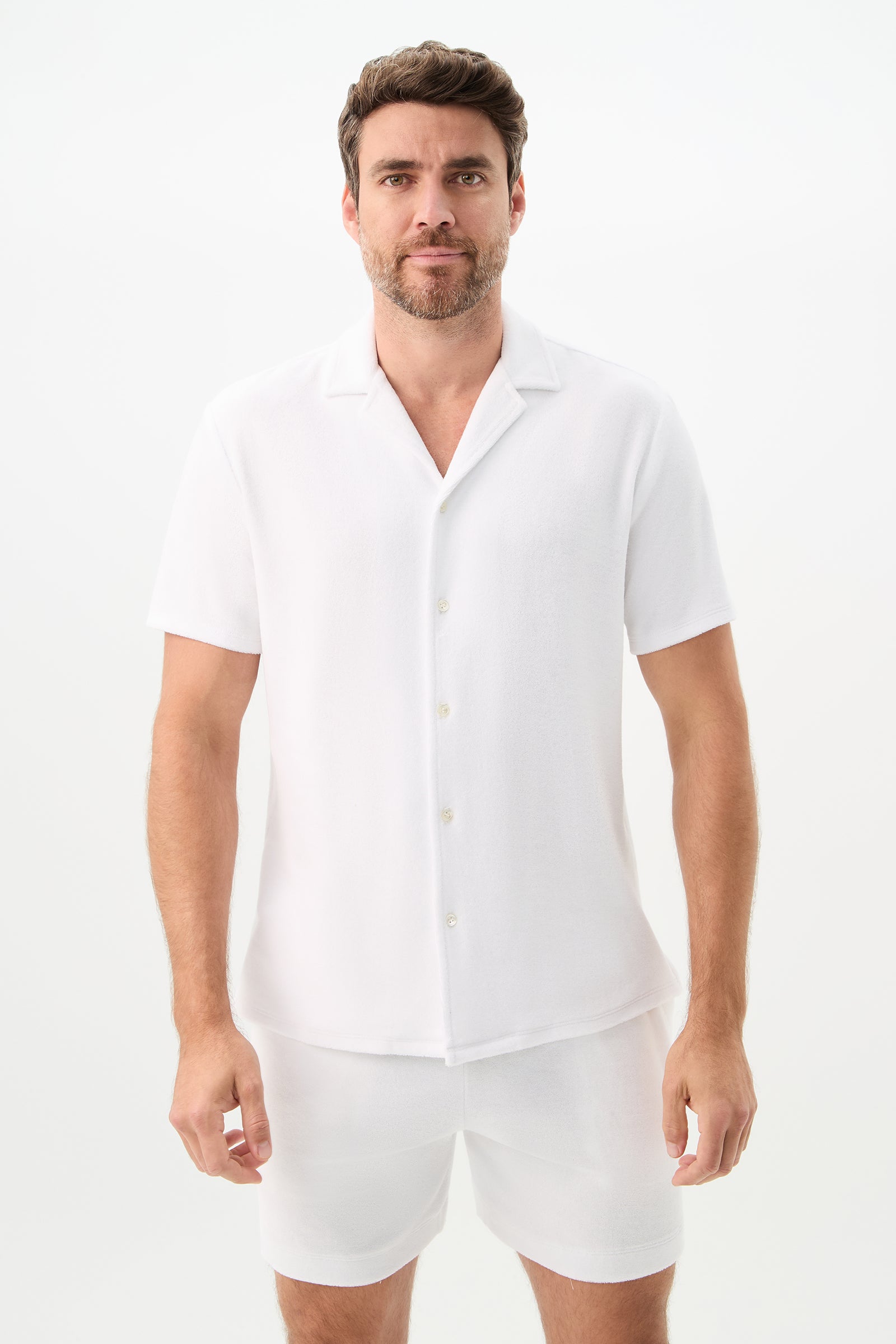 A man with short brown hair and a beard is wearing the Felix Short-Sleeve Knit Shirt – Linsk Terry in white, standing against a plain white background.