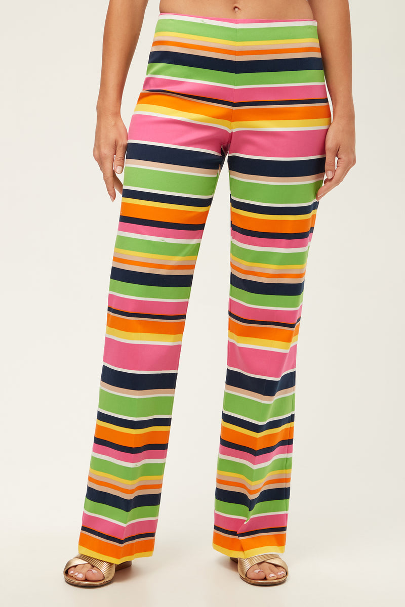A person wears the Rudi Straight-Leg Pant - Splash Stripe in multi, featuring bold, colorful horizontal stripes; only the lower torso and legs are shown.