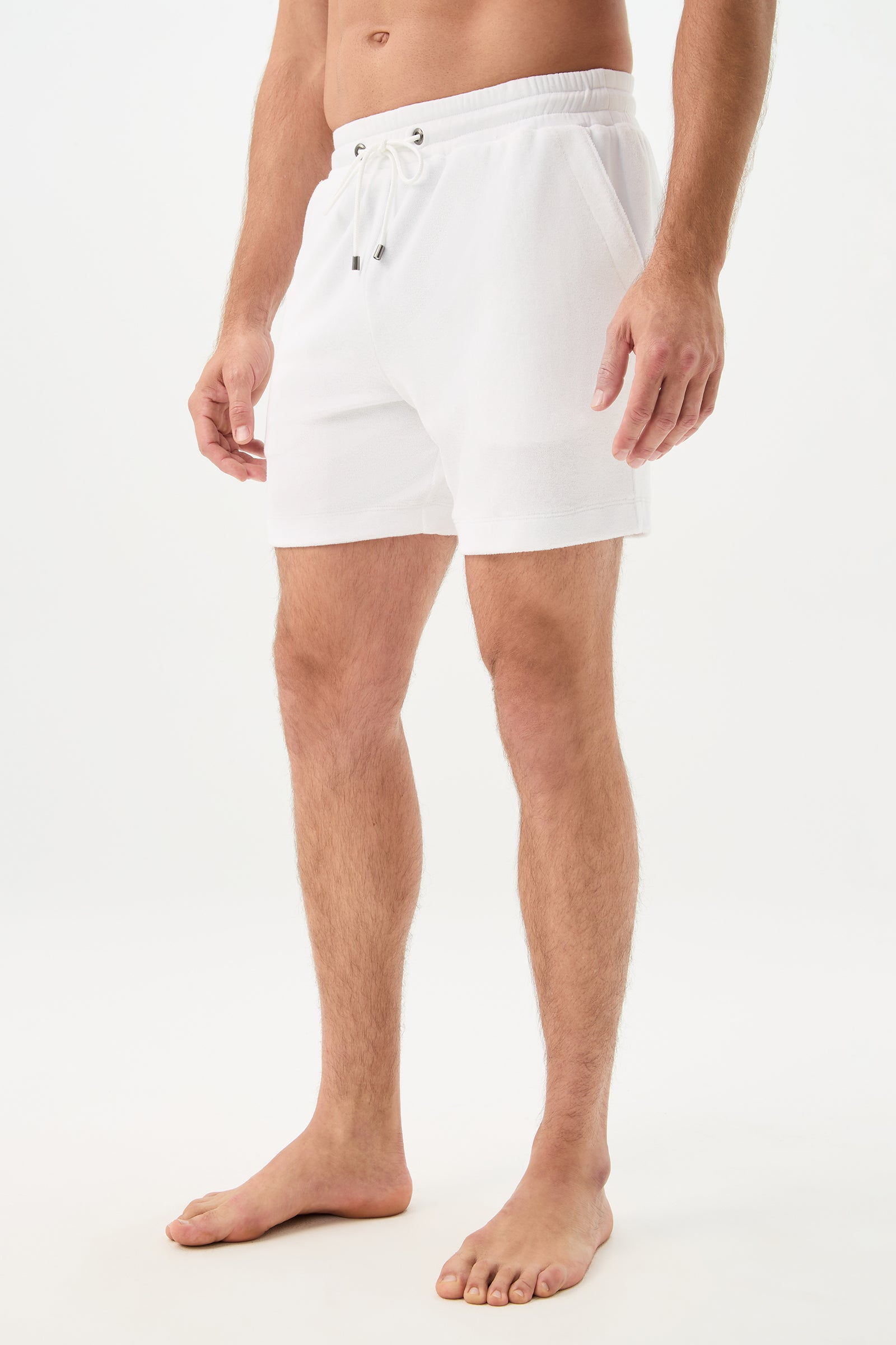 A barefoot man stands against a white background, wearing the Lounge Knit Short - Linsk Terry with drawstring and pockets. His upper body is not fully visible in the image.