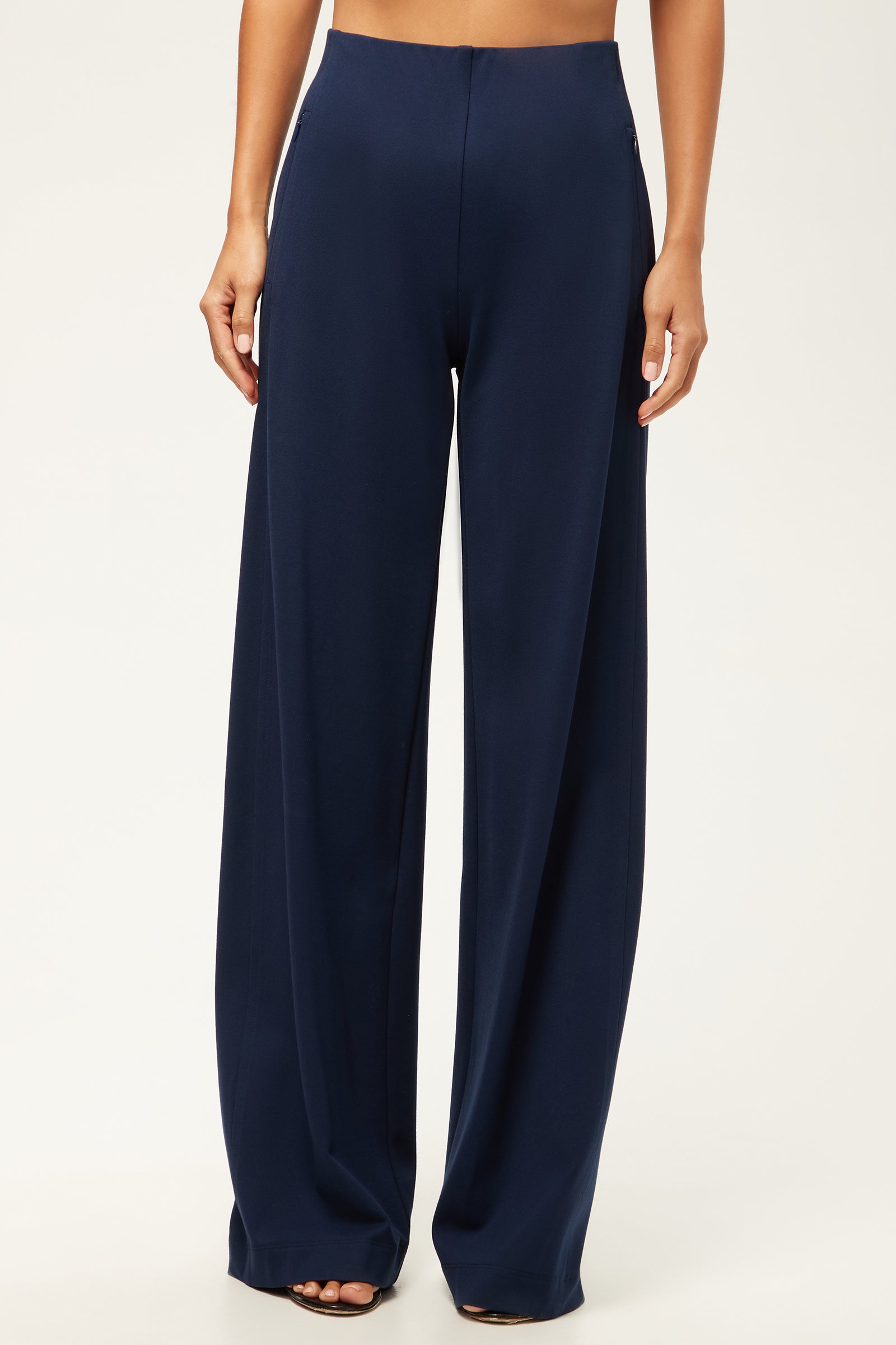 A person wearing the Record Essential Wide-Leg Pant - Cozy Ponte in navy blue with an elastic waistband, barefoot against a plain light background.