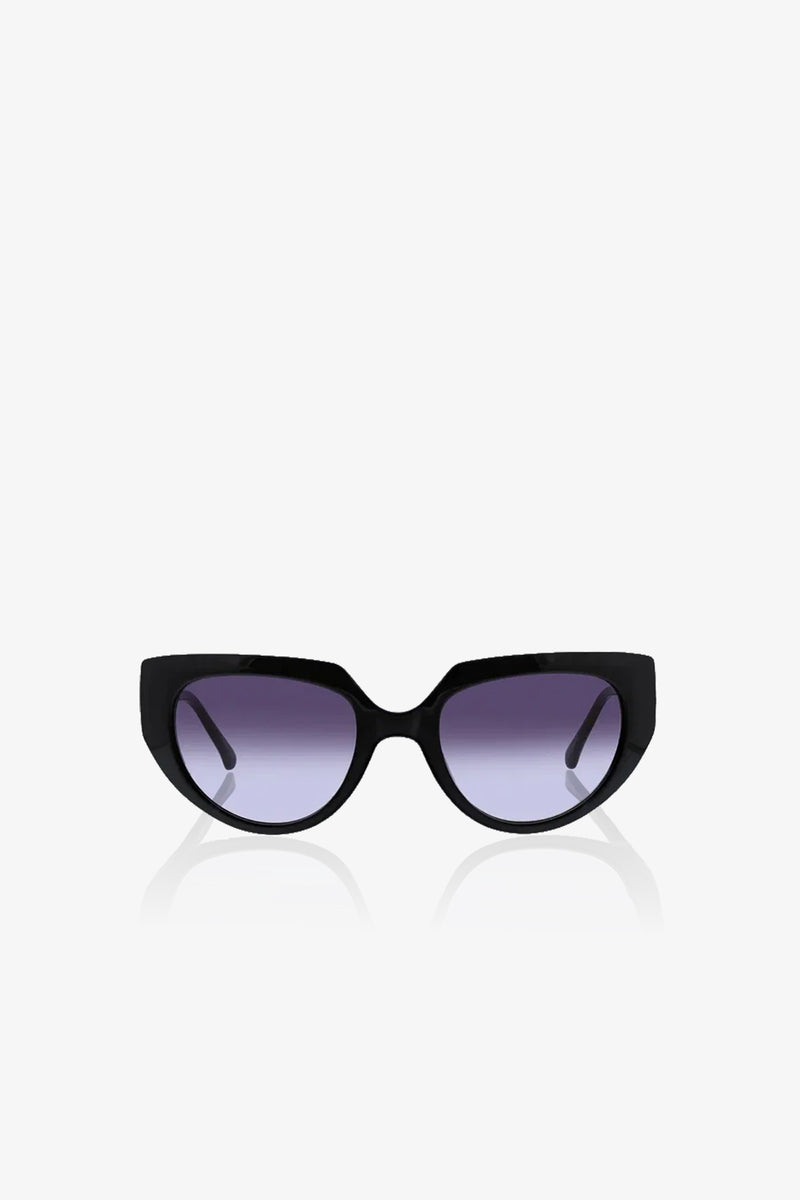 Schooner Sunglasses with a subtle cat-eye frame and dark, slightly gradient lenses are displayed against a plain white background, facing directly forward. The arms of the sunglasses extend outward and backward.