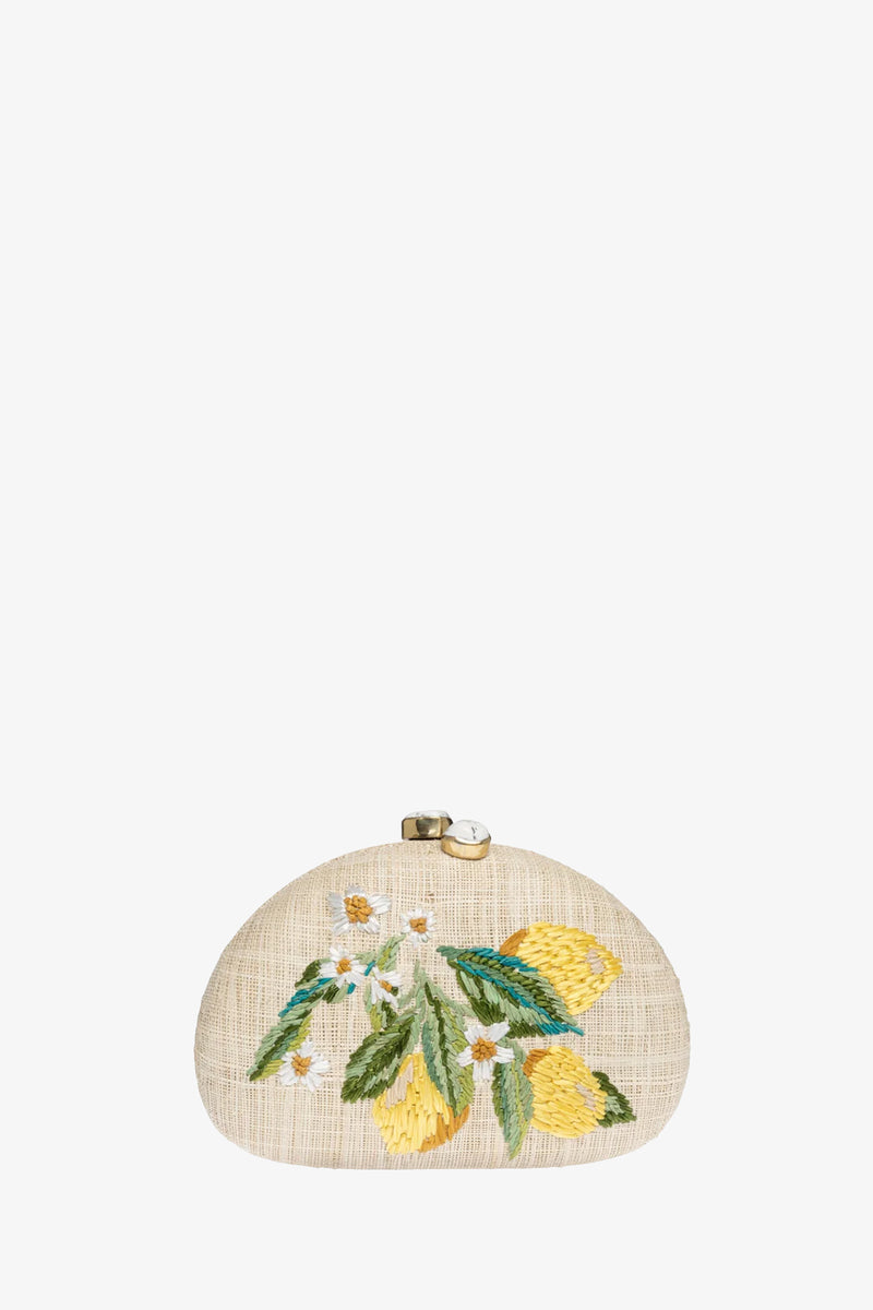 The RAFE BERNA LEMON CLUTCH is a small, rounded beige bag with a gold clasp, adorned with embroidered yellow lemons, green leaves, and white flowers on the front.