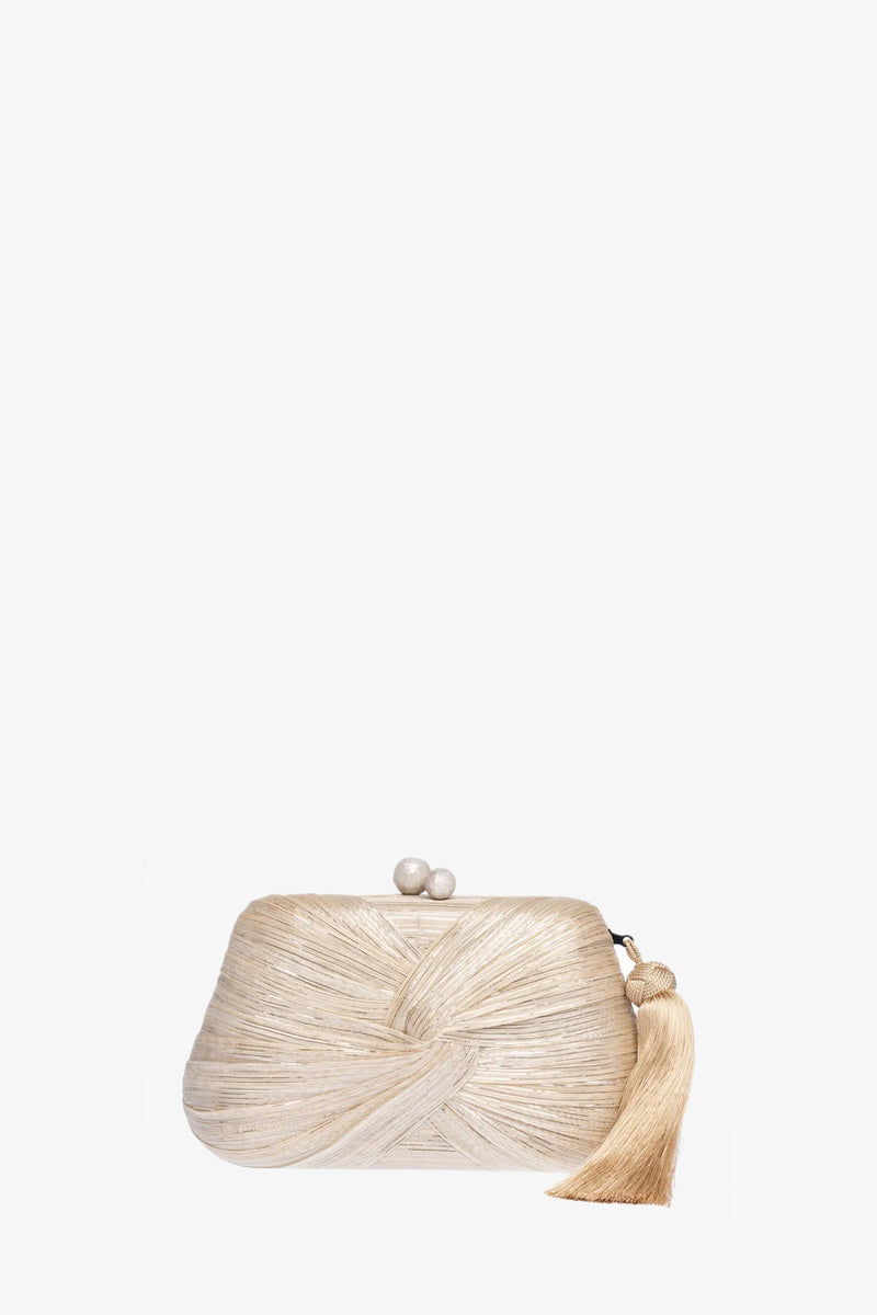 The Rosie Draped Clutch is a small, silver woven clutch bag featuring a knotted texture, pearl clasp, and matching silver tassel, displayed against a plain white background.