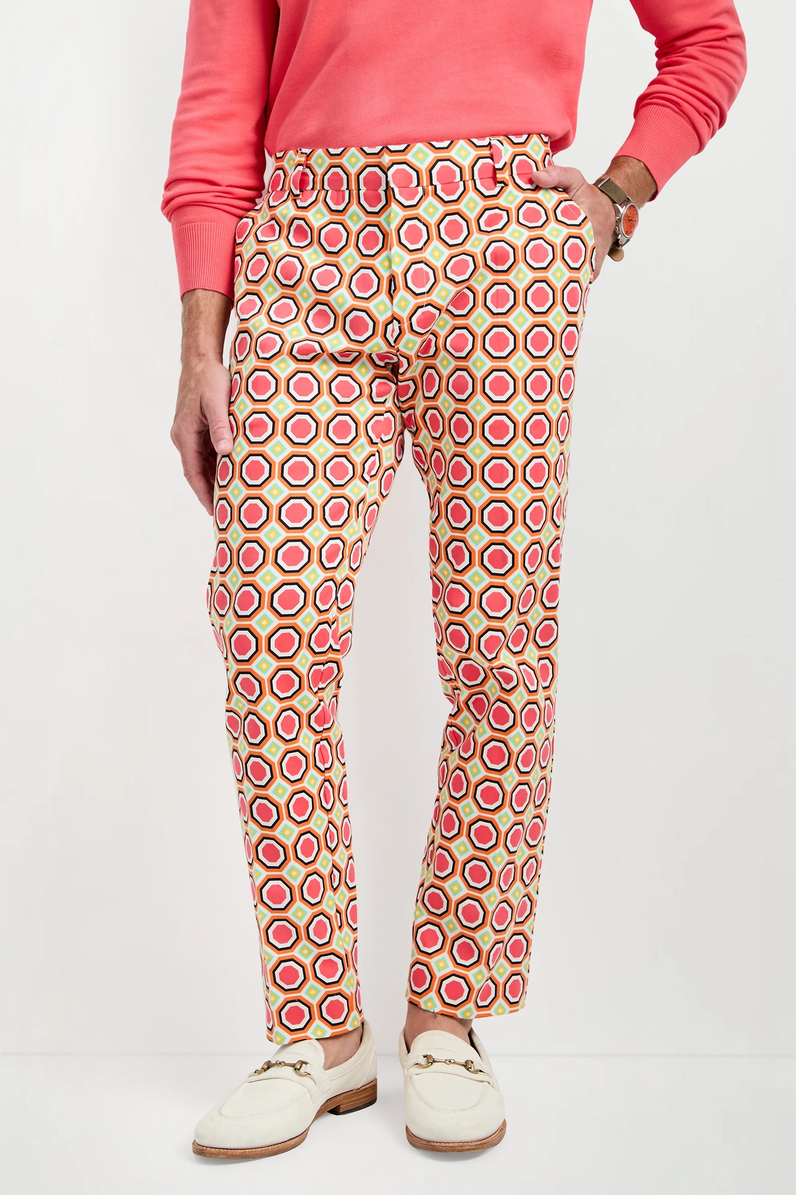 A person wearing the Clyde Slim Trouser - Salerno Herringbone, which features red, yellow, and white geometric circles, stands against a plain background. Only the lower torso and legs are visible.