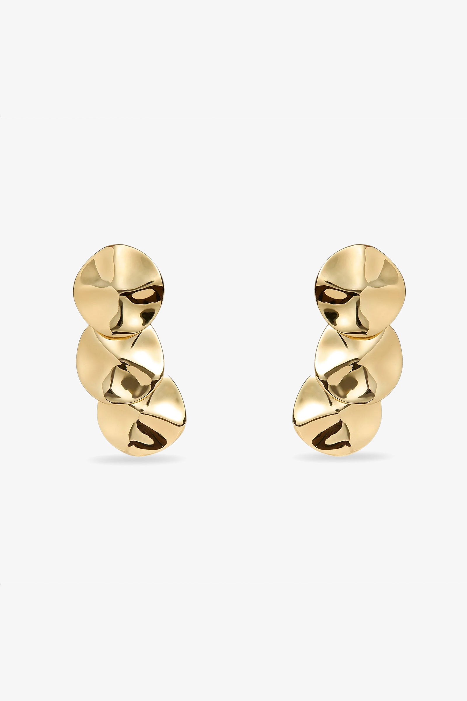 The Socialite Statement Earrings feature three gold, disc-shaped pieces with a shiny, slightly hammered finish arranged vertically against a plain white background.