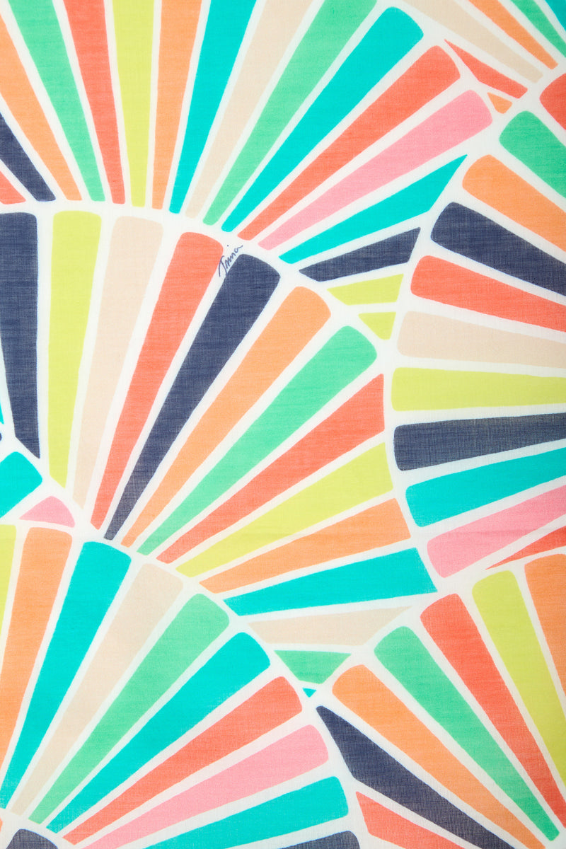 Radiating from multiple points on a white 100% cotton background, the COTTON BANDANA features an abstract pattern of colorful, overlapping rays in turquoise, orange, pink, yellow, navy, and lime that resemble fan shapes or sunbursts.