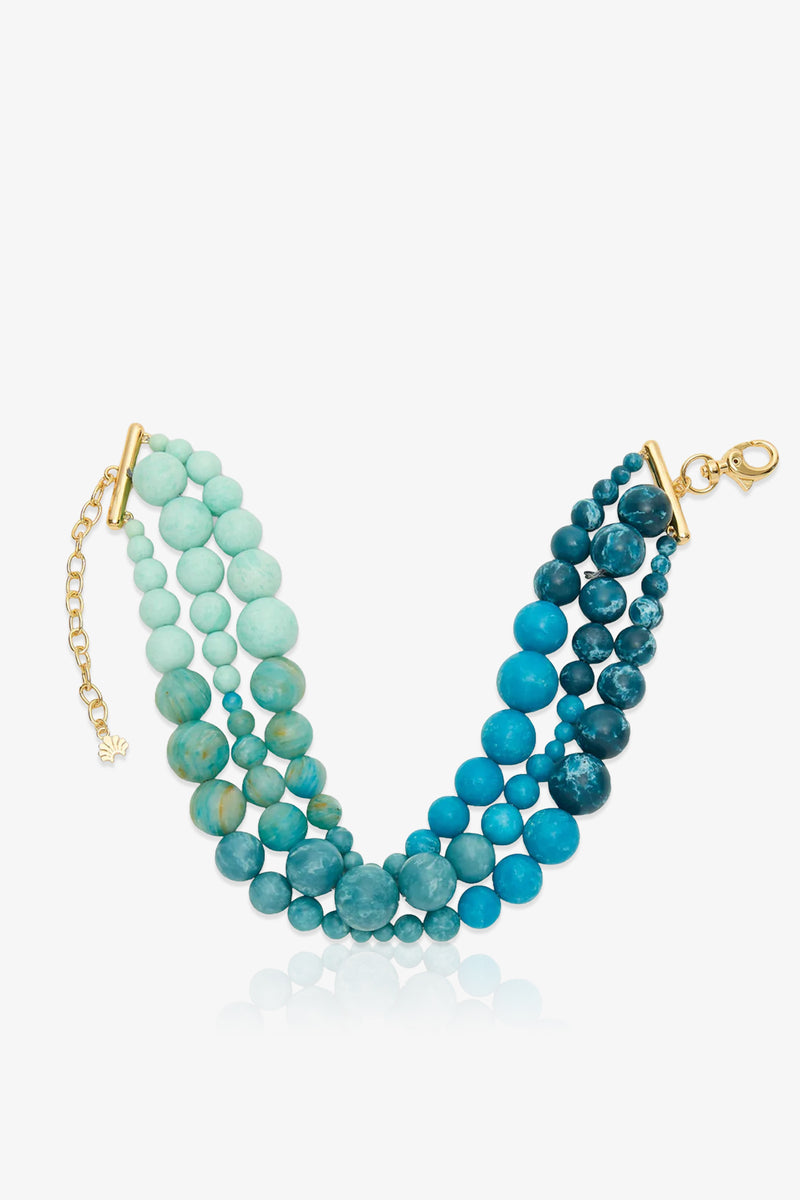 Riviera Diana Triple Row Necklace with round beads in gradient shades of turquoise blue, featuring gold-tone metal clasps and an adjustable chain.