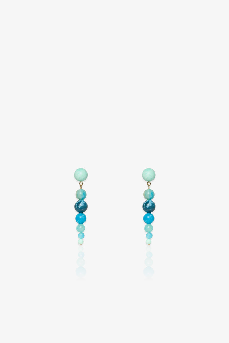 Introducing the Riviera Linear Drop Earrings: a pair of drop earrings featuring four round beads each, arranged vertically in gradient shades of blue against a white background.