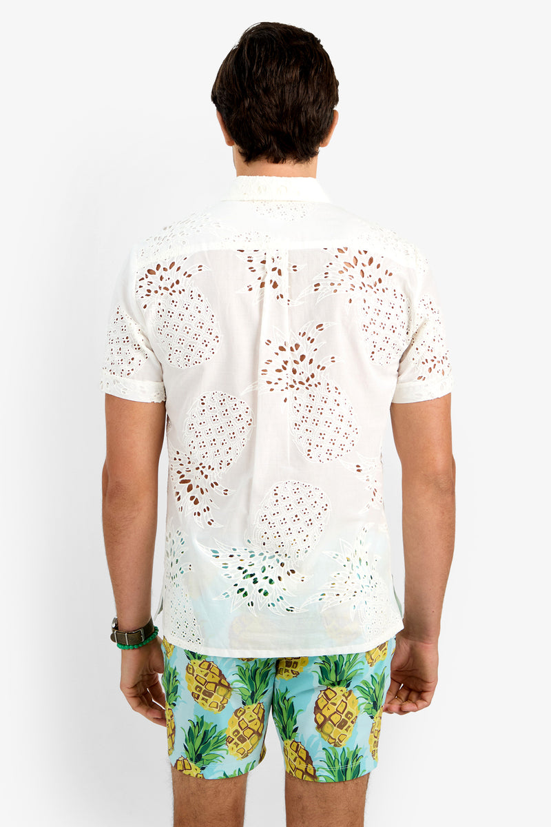 A man stands with his back to the camera, wearing a white short-sleeve BRANSON SHIRT and colorful pineapple-print shorts against a plain white background.