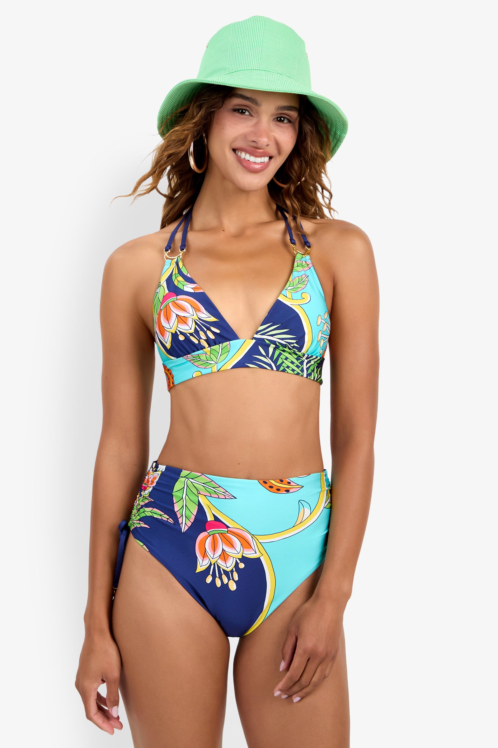 A woman in a Banded Halter Bikini Top and a light green bucket hat smiles at the camera against a white background.