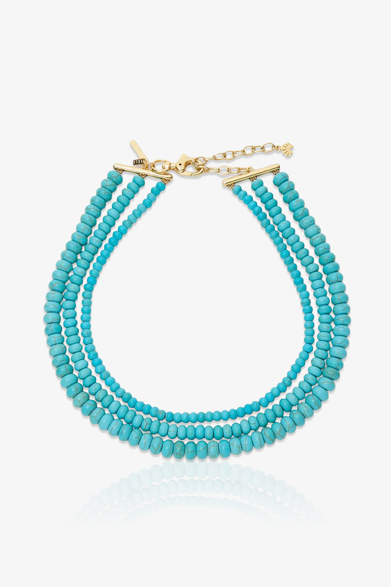 Turquoise Multi Strand Necklace featuring triple strands of turquoise beads, a gold clasp, and an adjustable chain, showcased on a white background.