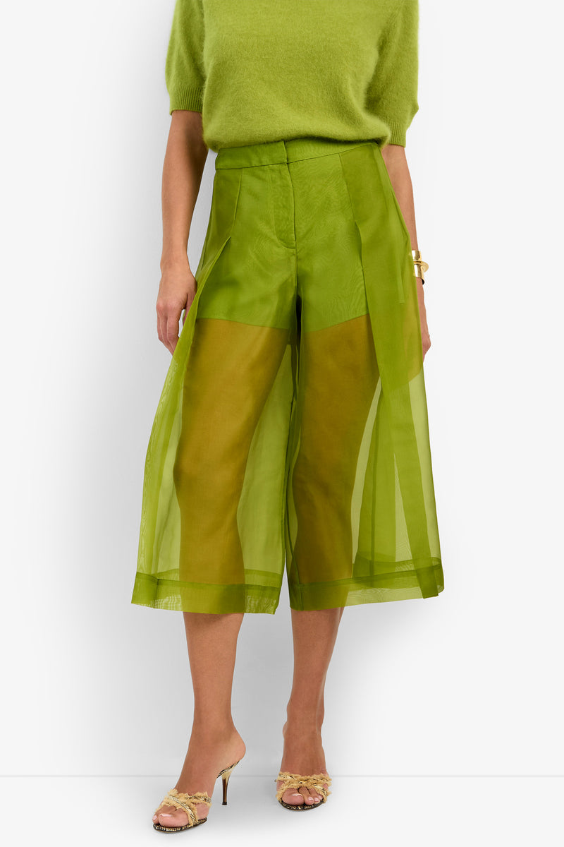 A person wearing a green fuzzy short-sleeve top and sheer green wide-leg Siena Pant, paired with open-toed heeled sandals.