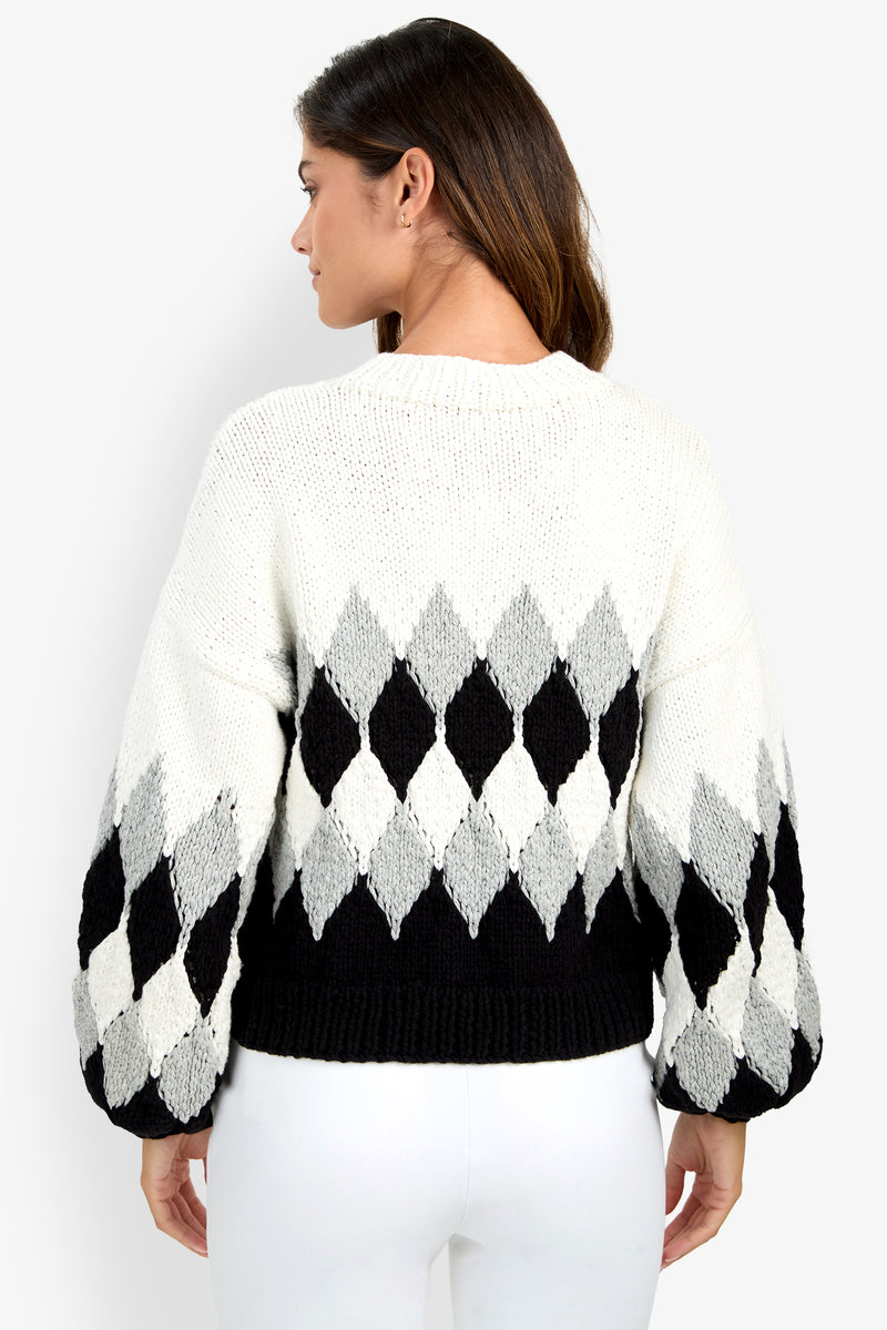 A woman wearing a white, black, and gray argyle-patterned Cavallari Sweater viewed from the back.