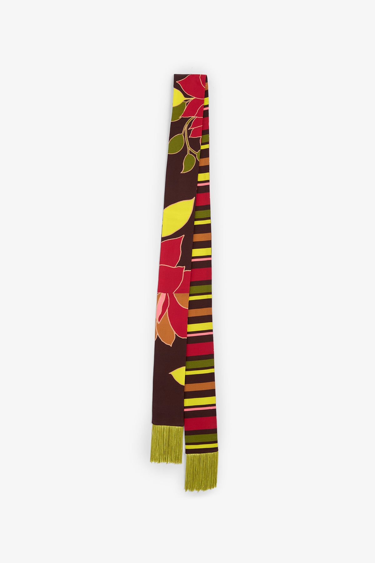 The SERA FRINGE SCARF is a long accessory adorned with bold floral and striped patterns in red, yellow, and green on a brown background, finished with green fringe at one end.