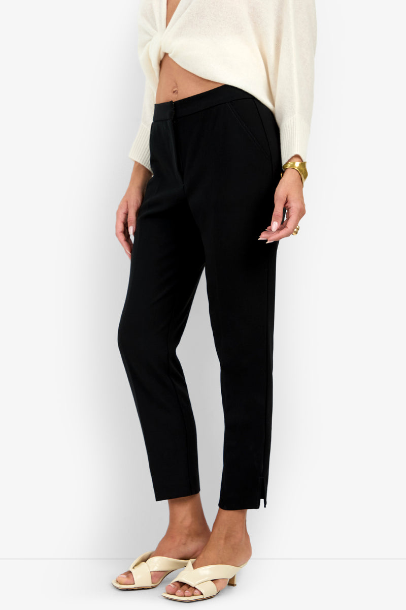 Black ARNO PANT ankle-length trousers with a slim fit and a small side slit at the hem.