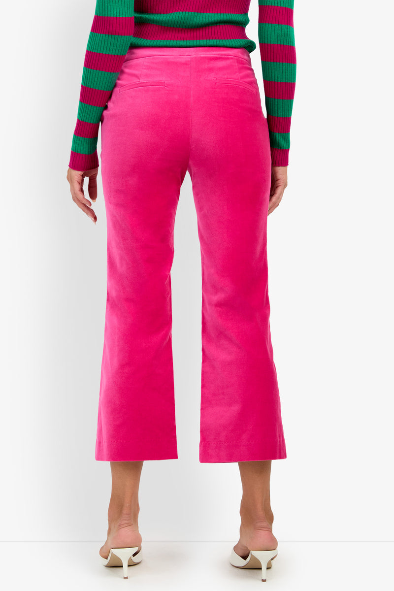 A person wearing the Westport Crop in bright pink, a green and red striped sweater, and white heeled sandals, shown from the back against a white background.