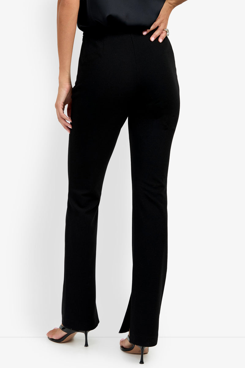 A person shown from the back against a white background wearing the Milena Pant and black heeled sandals.