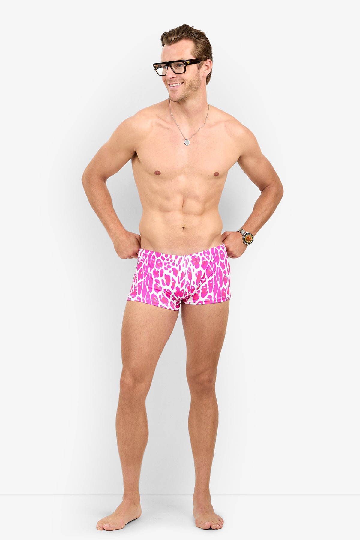 A man wearing pink and white animal-print MONTEGO BAY SWIM TRUNK.