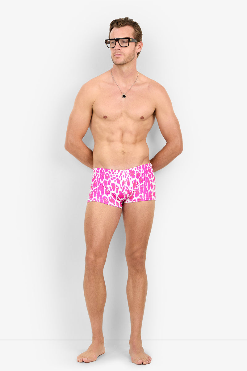 A man wearing black-rimmed glasses and pink and white animal-print MONTEGO BAY SWIM TRUNK.