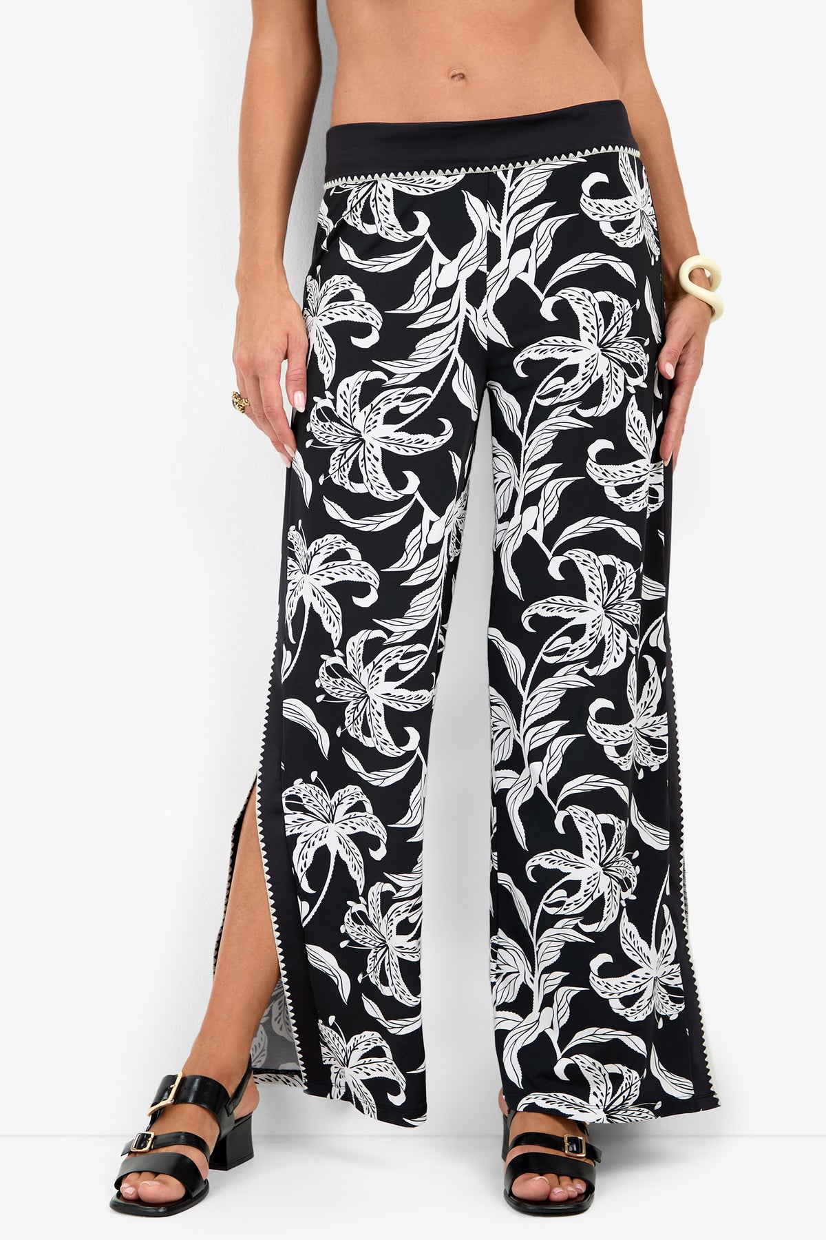 GOLDEN HOUR BLOOM SWIM PANT in a black and white floral print with a fold-over waistband and side slits, styled with black heeled sandals.