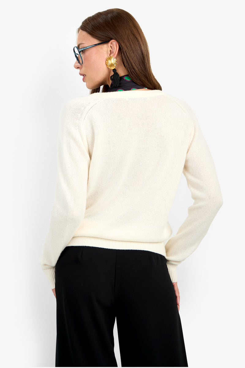 Back view of a person wearing an EVANGELINE SWEATER in cream-colored 100% cashmere with black trousers.