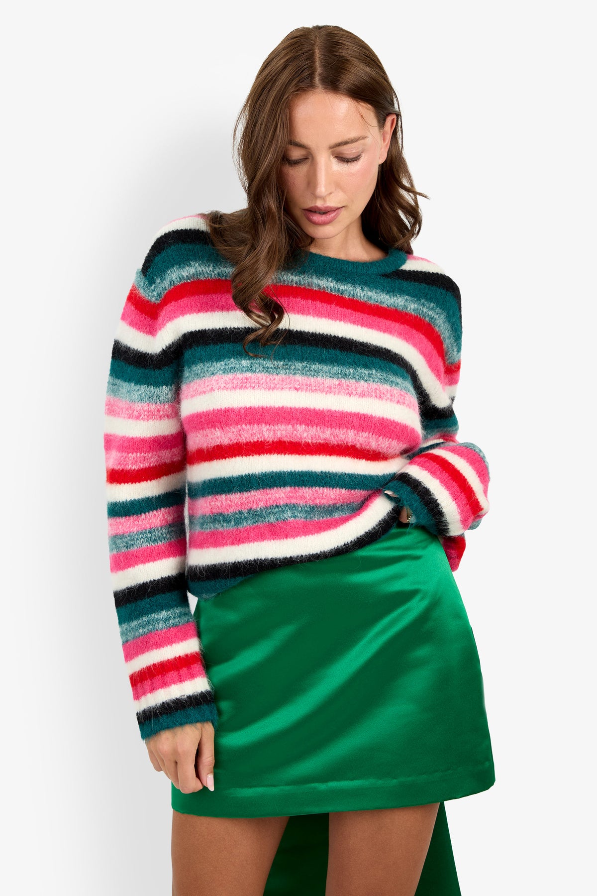A woman wearing a fuzzy, multi-colored striped BARDINI PULLOVER and a green spandex mini skirt.
