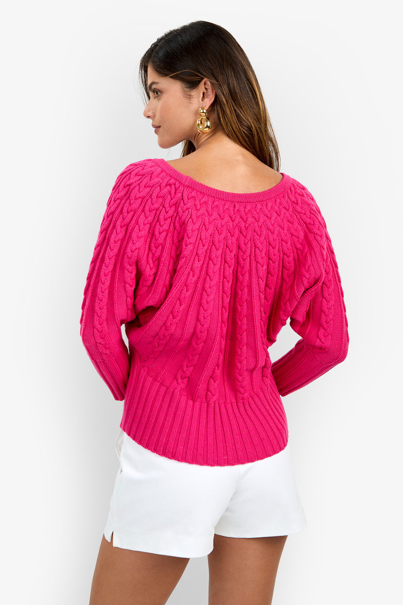 Back view of a person wearing a bright pink Tyson Knit Sweater with a wide neckline and ribbed hem.