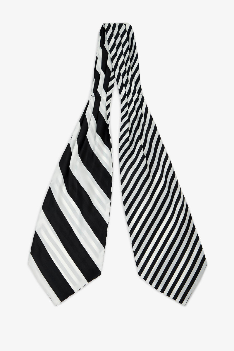 The Savoir Stripe Silk Ascot features two wide ends with contrasting black and white diagonal stripes—the left side showcases bold, thick stripes, while the right side displays thinner, closely spaced stripes.