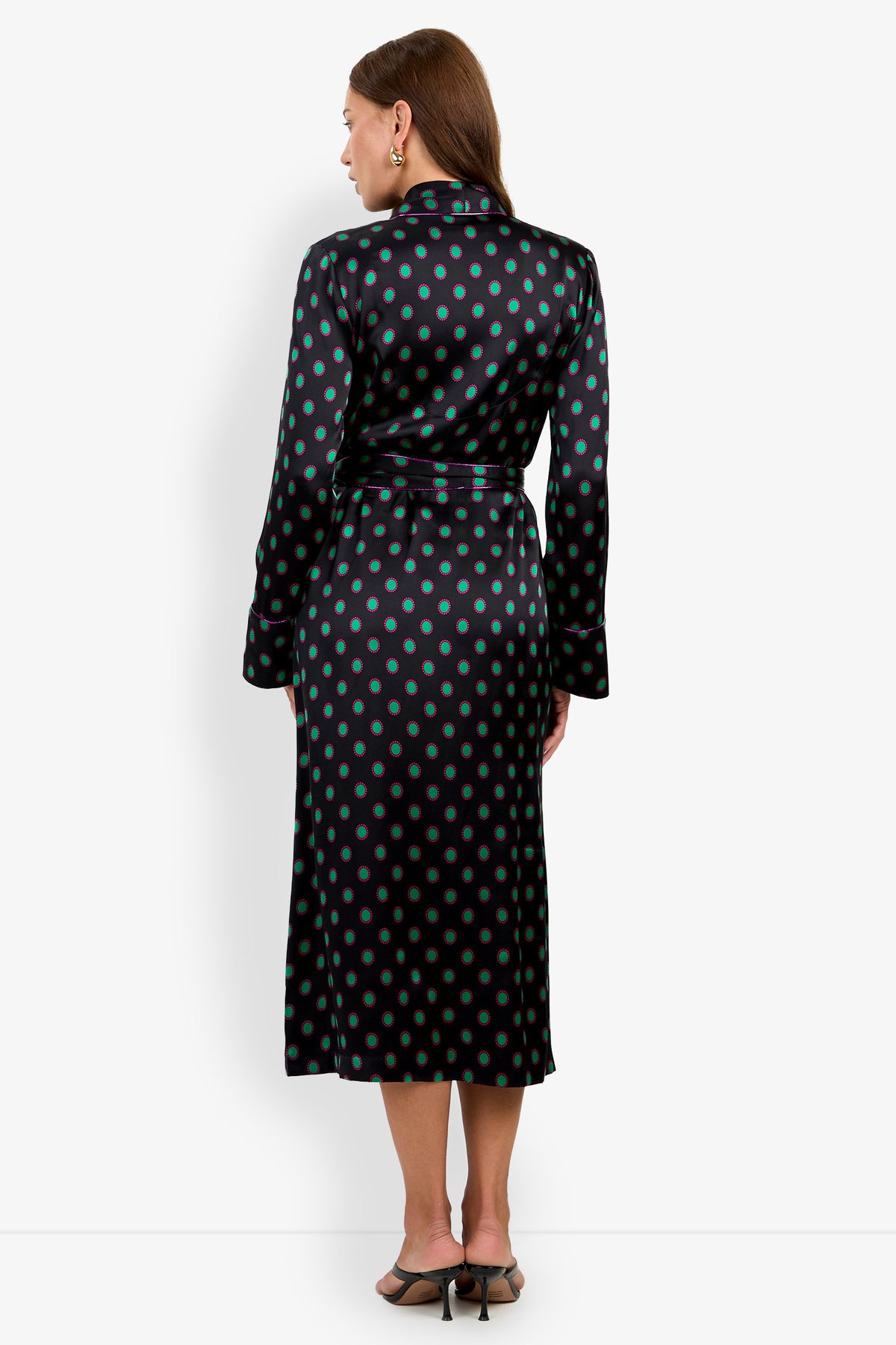 A person wearing the ADALYNN ROBE, a mid-length robe in black 100% silk with a green and magenta polka dot pattern, tied at the waist with a belt.