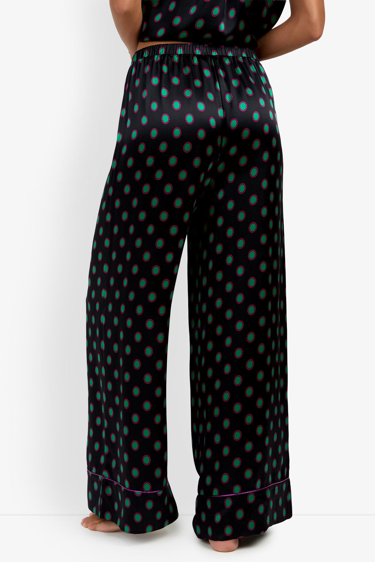 LIARA PANT wide-leg trousers in black silk featuring a repeating green and magenta oval pattern and pink piped hems.