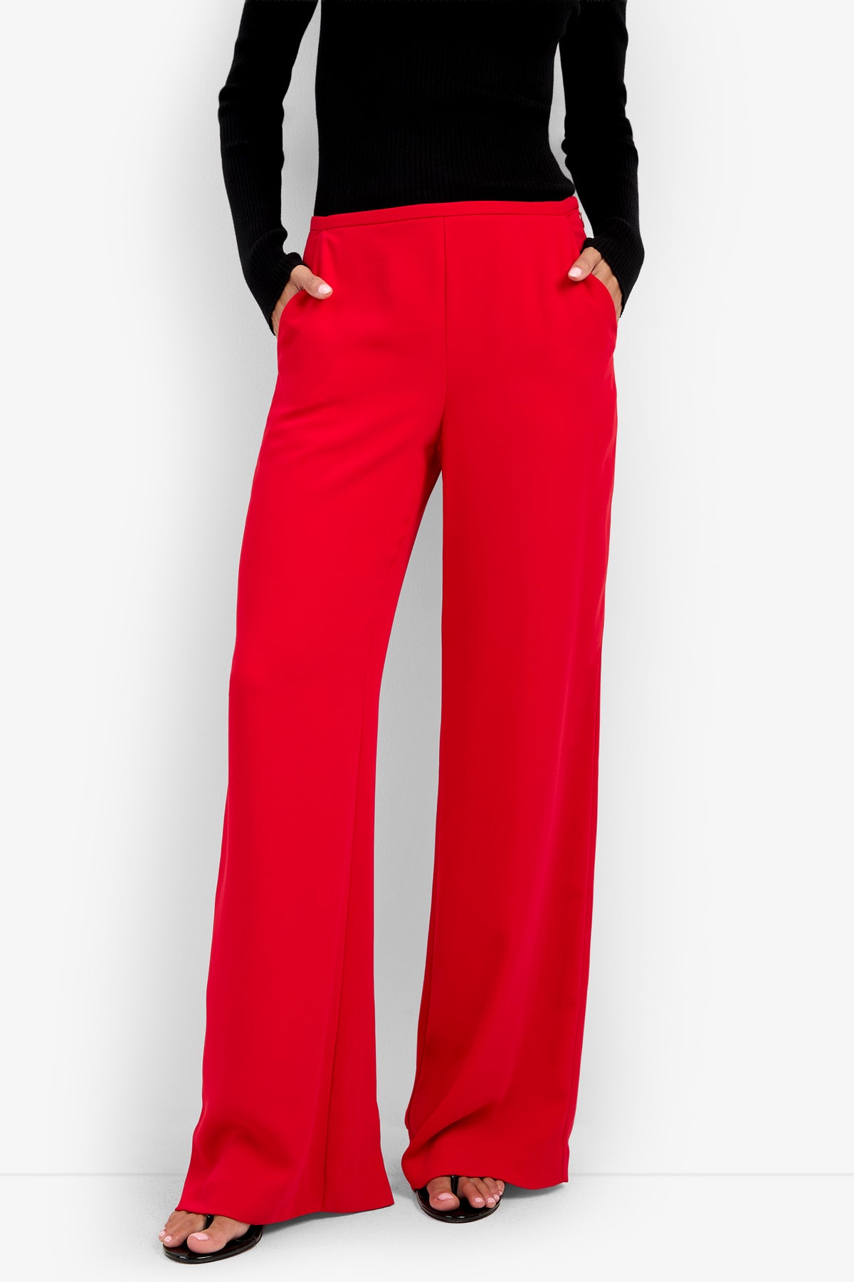 TAVIA PANT high-waisted bright red wide-leg polyester trousers with side pockets, worn with a black long-sleeved top.