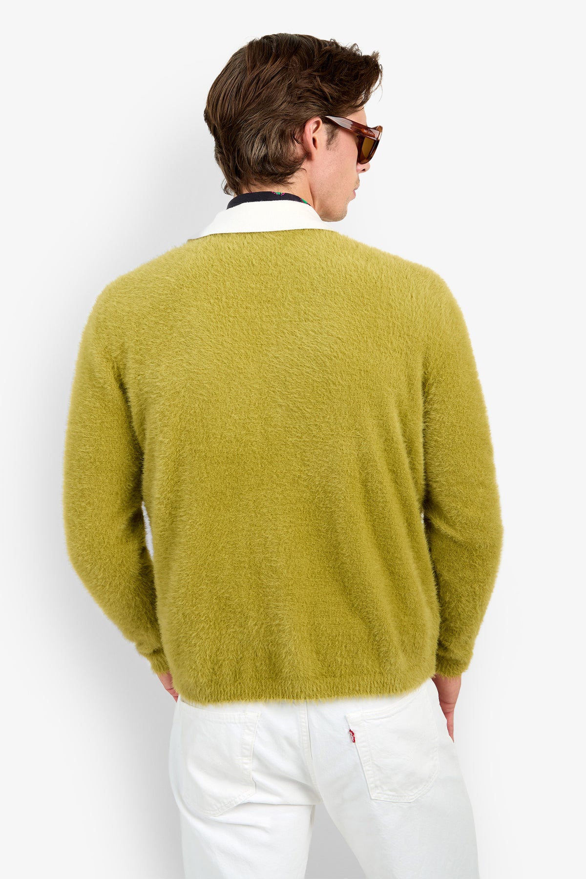 Back view of a person wearing a fuzzy chartreuse SCOTT FUZZY CARDIGAN with a white collar over a white shirt and white jeans.