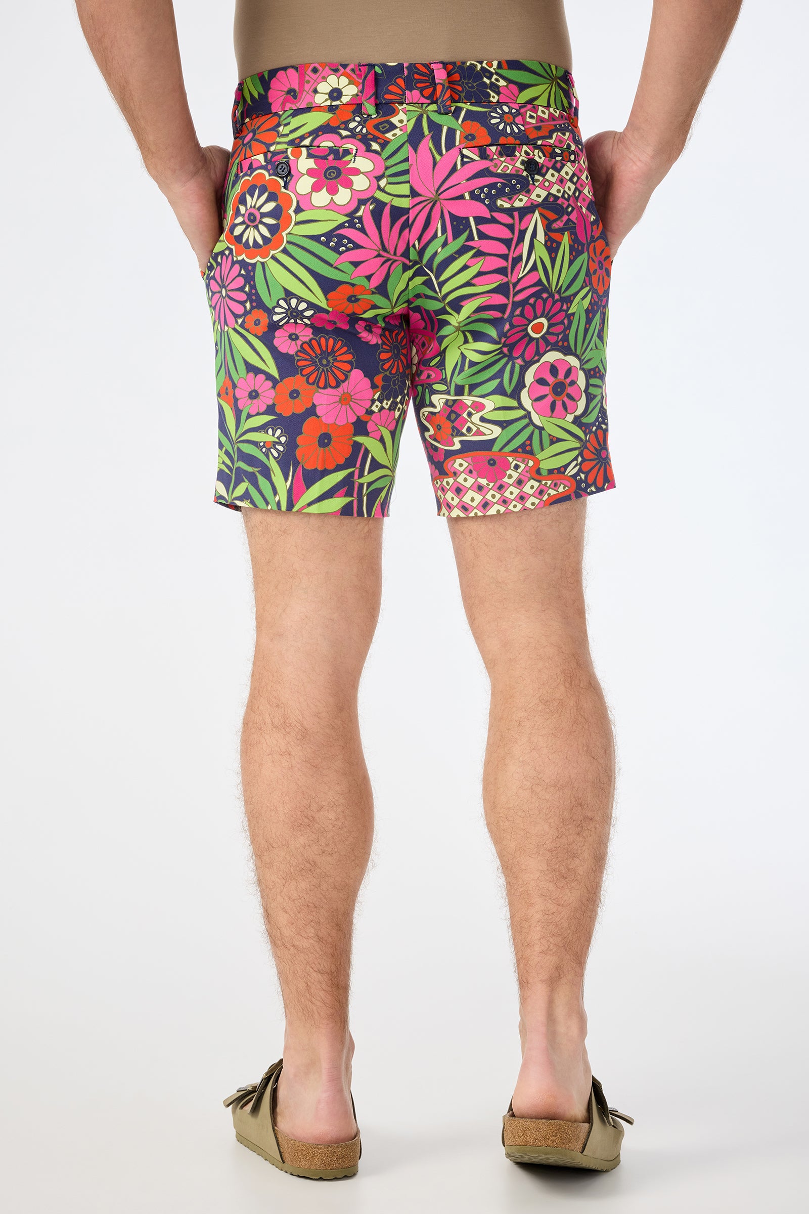 A person is seen from the back wearing the Lawrence Short - Fumi Floral, paired with a tan shirt and brown slip-on shoes against a plain white background.