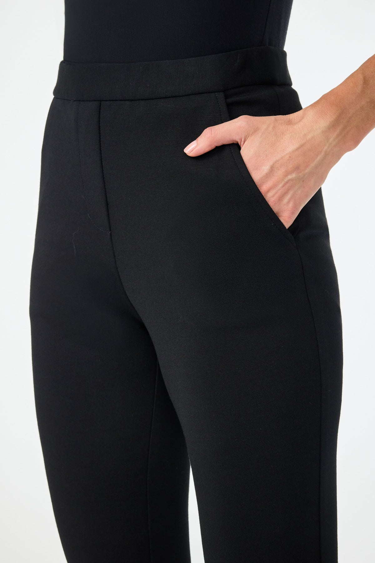 A person wearing Honey Straight Leg Pants and a black top stands with one hand in their pocket against a plain white background.