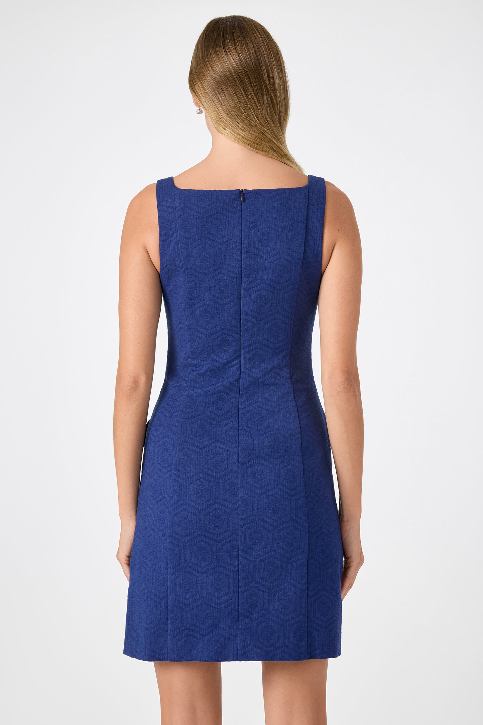 A woman with long, light brown hair wears the Shinra Button-Down Mini Dress and stands with her back to the camera against a plain white background.