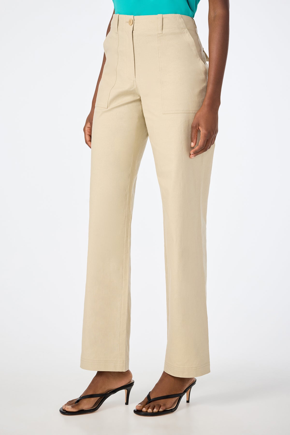 Someone wearing Antonia 2 Straight Leg Pants in beige, styled with black heeled sandals and a turquoise top. The image is cropped from the shoulders down against a plain white background.