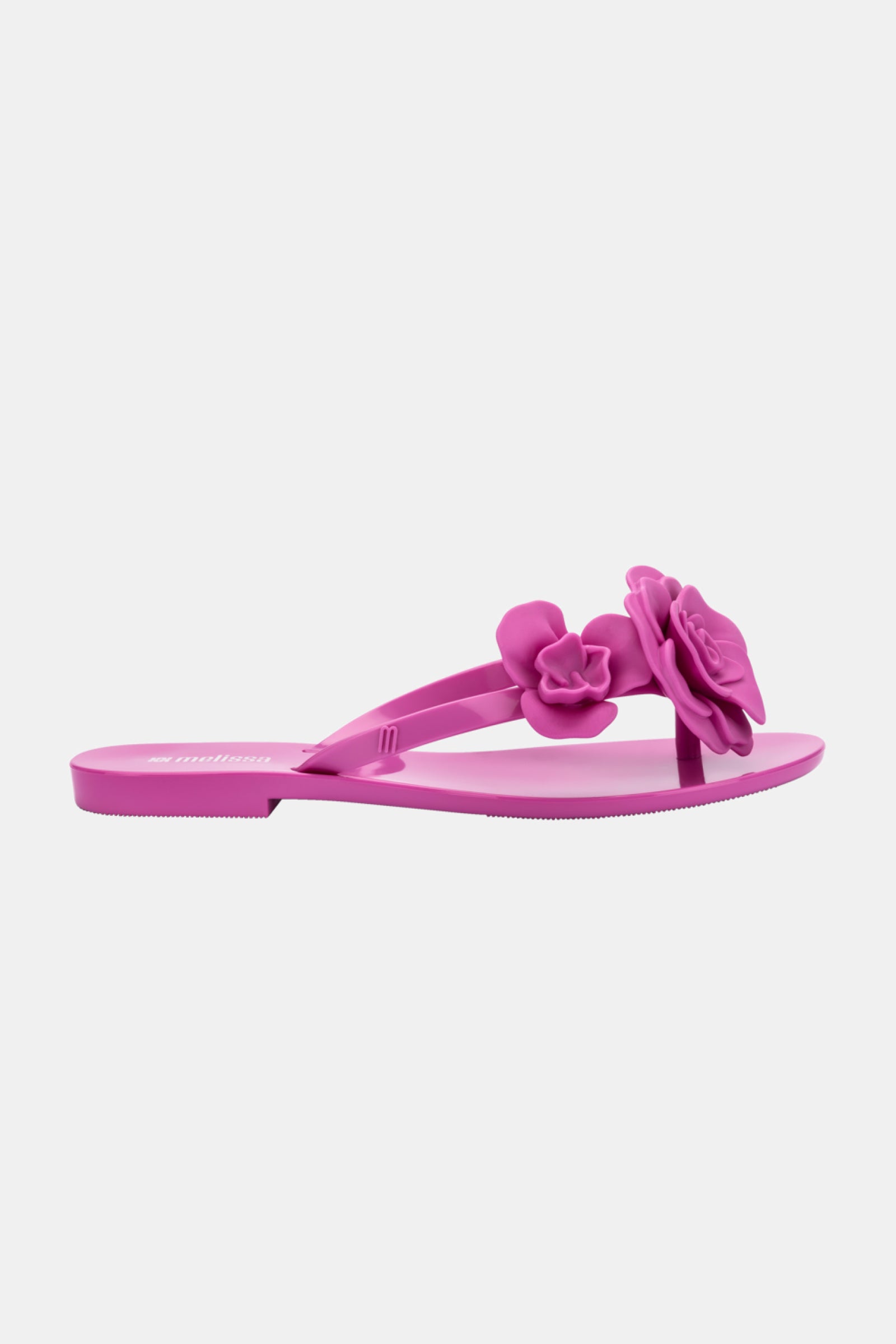 The Melissa Harmonic Petals Sandal is a pink flip-flop with two 3D flower decorations on the straps, displayed against a plain white background.