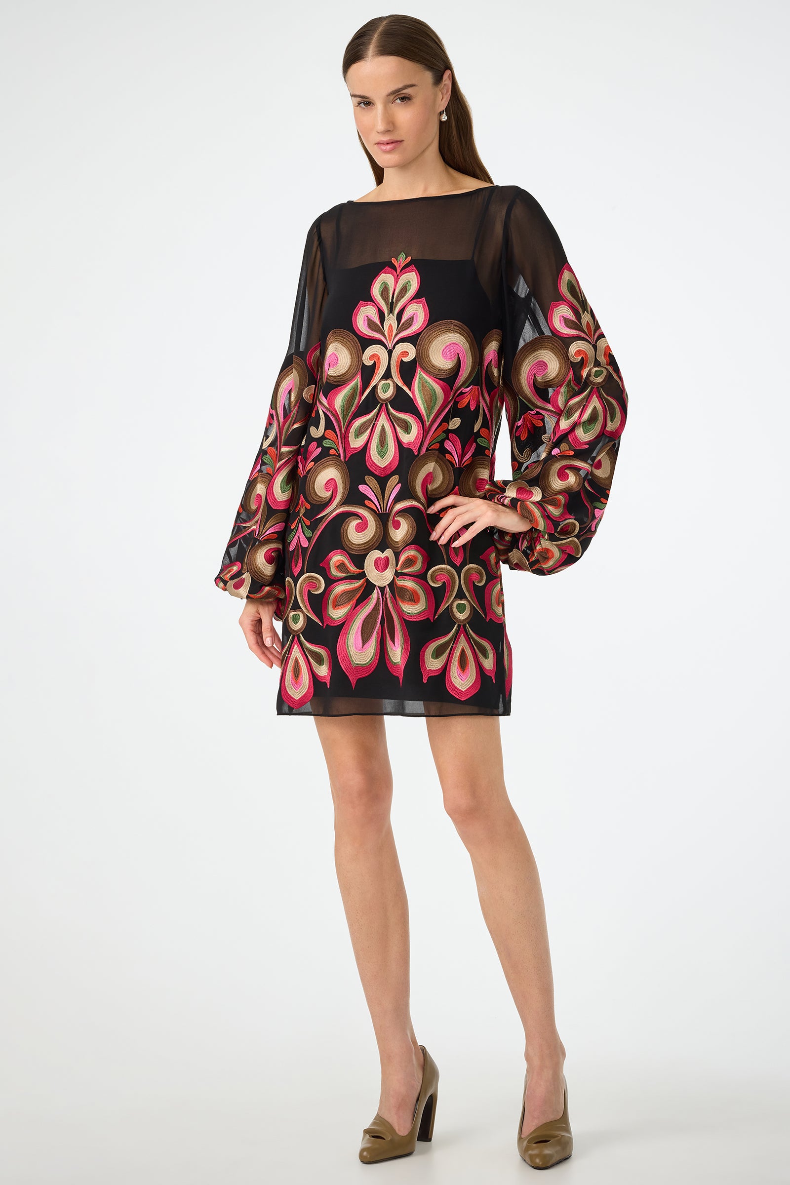 A woman poses against a plain white background wearing the Salim Embroidered Mini Dress in Sanctuary, featuring colorful embroidery and long voluminous sleeves, paired with taupe high-heeled shoes.