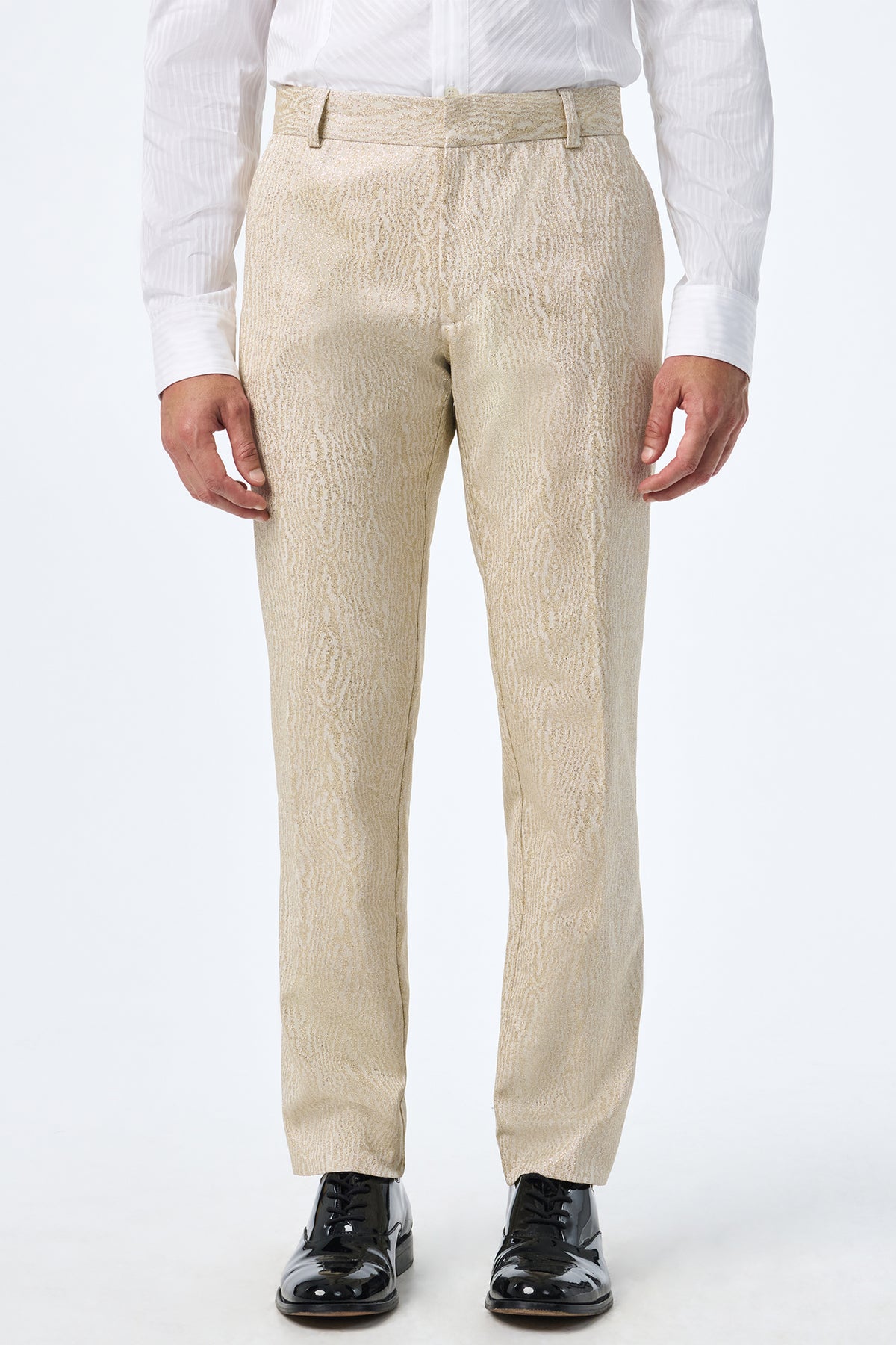 A person wearing Clyde Slim Trouser in light beige, a white dress shirt, and black shiny dress shoes stands against a plain white background.