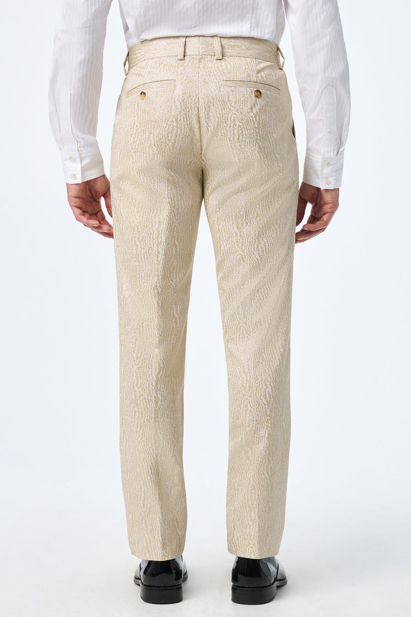 A person is seen from behind, wearing Clyde Slim Trouser in light beige with a white long-sleeve dress shirt and black dress shoes, standing against a plain white background.