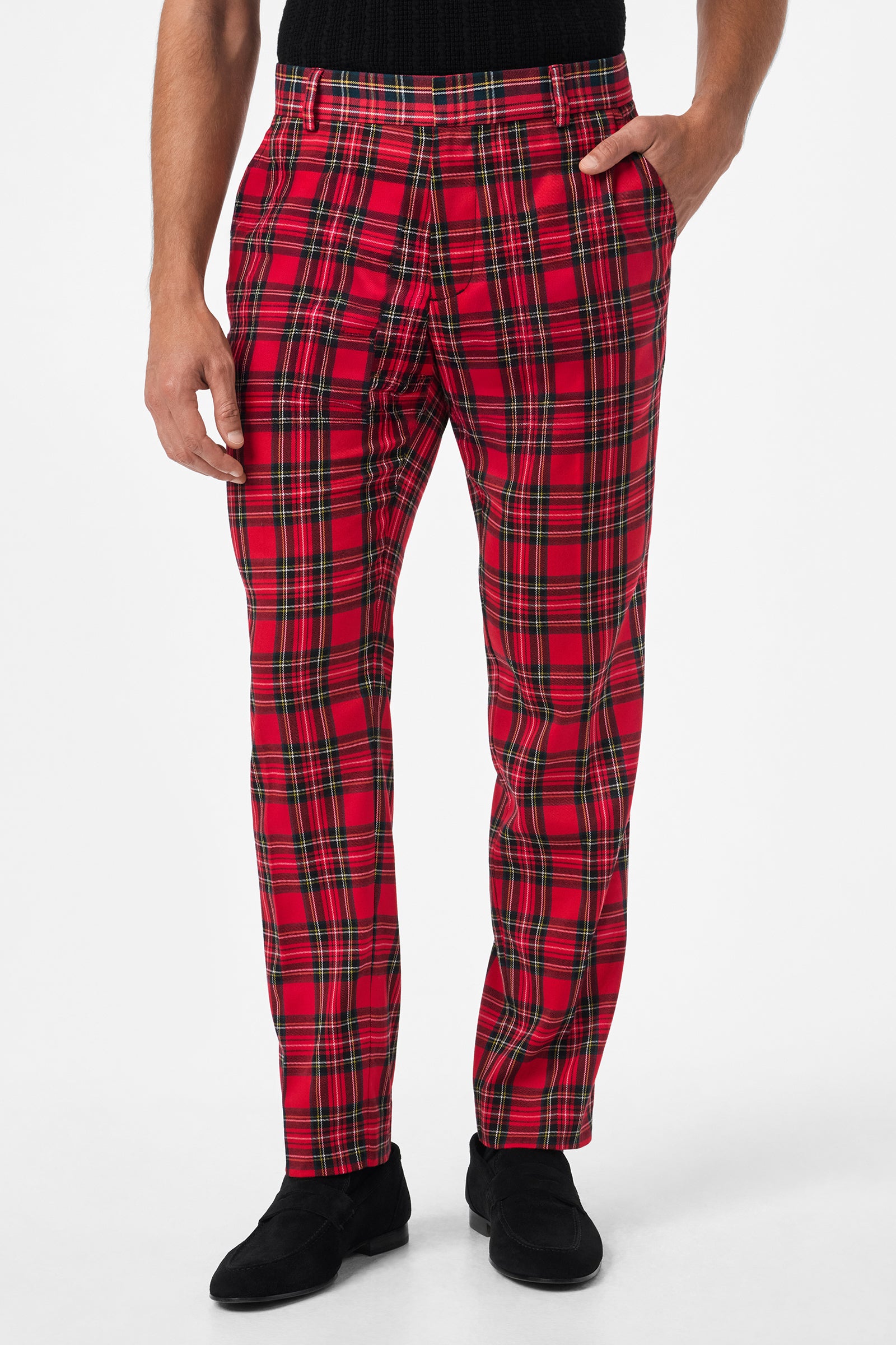 A person wearing the Clyde Slim Trouser - Can-Can Check, featuring red plaid with black, yellow, and white stripes, paired with a black shirt and black shoes, stands against a plain white background.