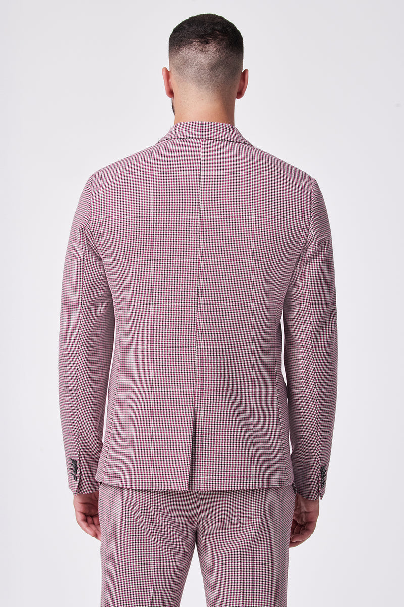 A man faces away from the camera in a fitted THURSTON BLAZER, a pink and white checkered suit made from a soft viscose blend with added elastane stretch, set against a plain white background.