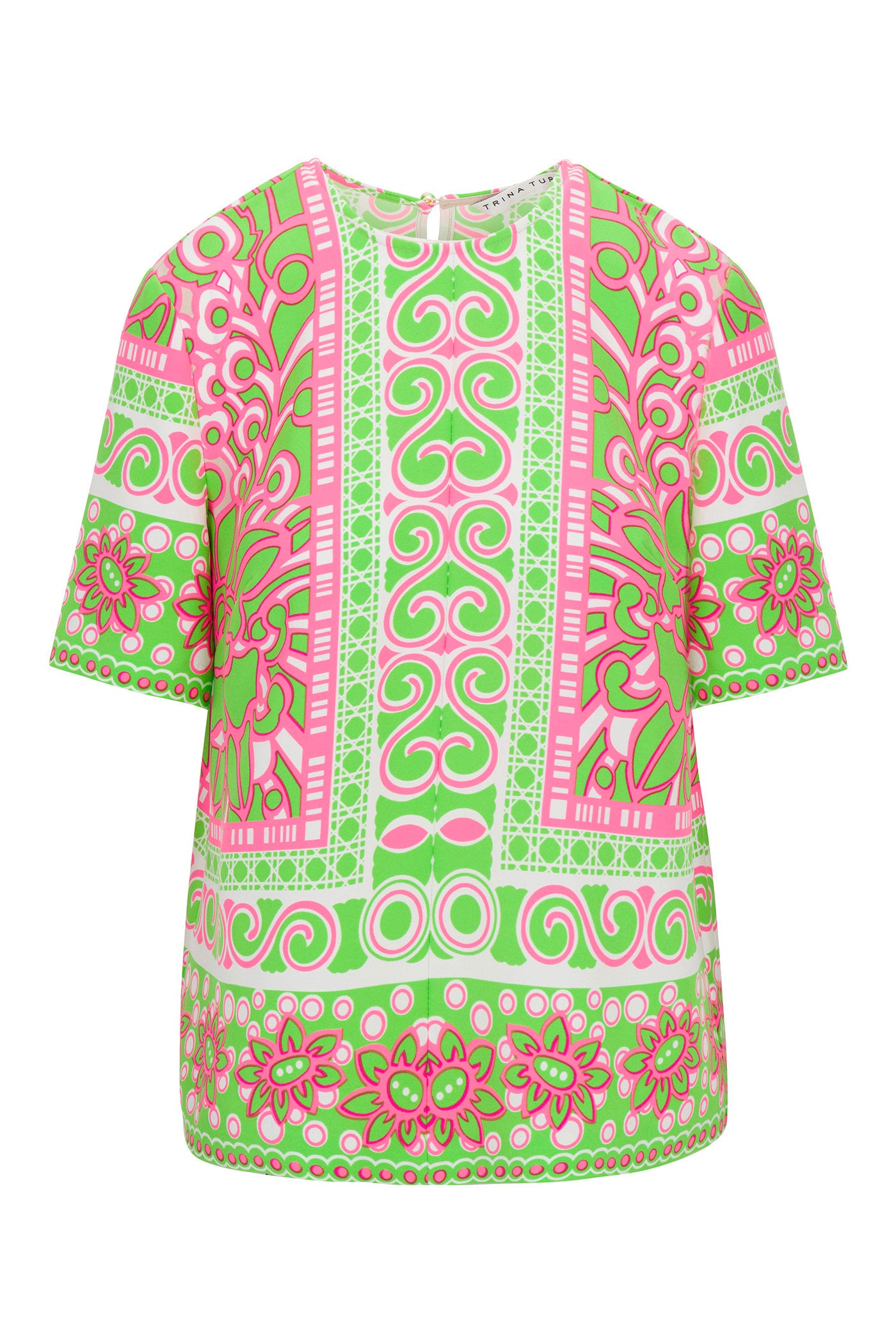 The Riggs Short-Sleeve Top - Petra Floral features a bold pink, green, and white geometric and floral pattern with intricate swirls, flowers, and shapes on the front plus a classic crew neckline.