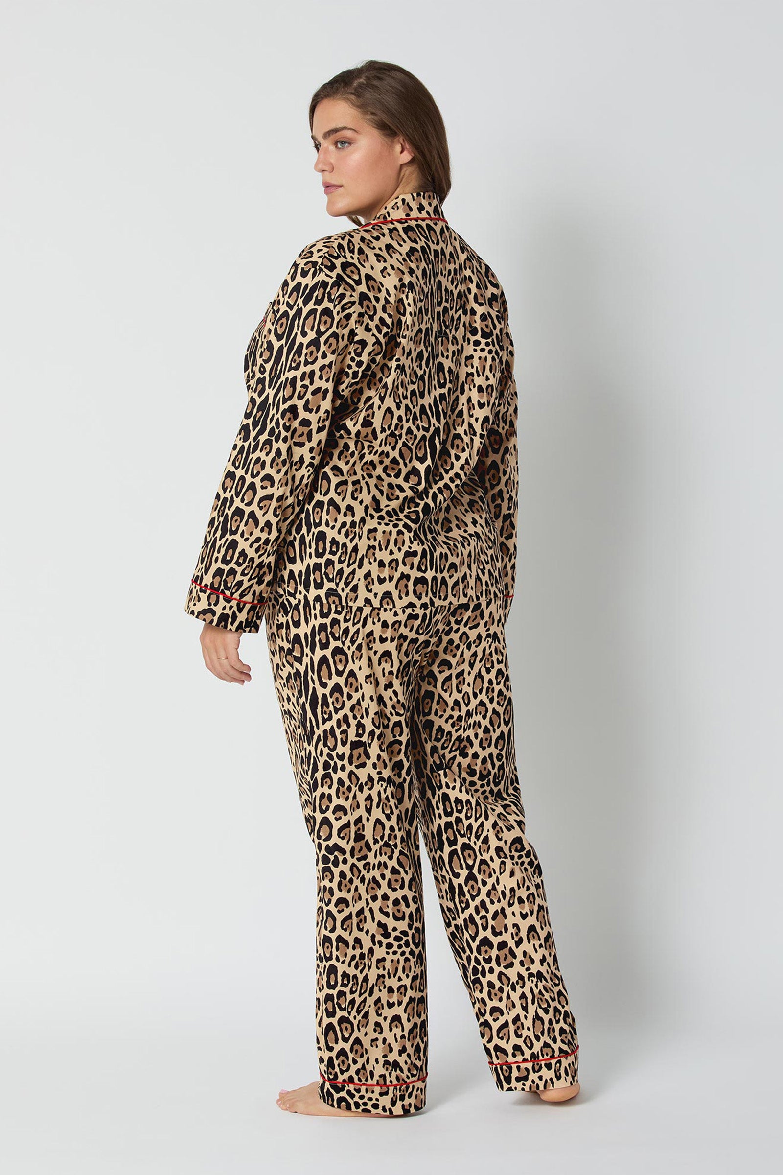 A woman stands barefoot, facing sideways while looking back at the camera, wearing the Leopard Stripe L/S Classic Pj set against a plain white background.