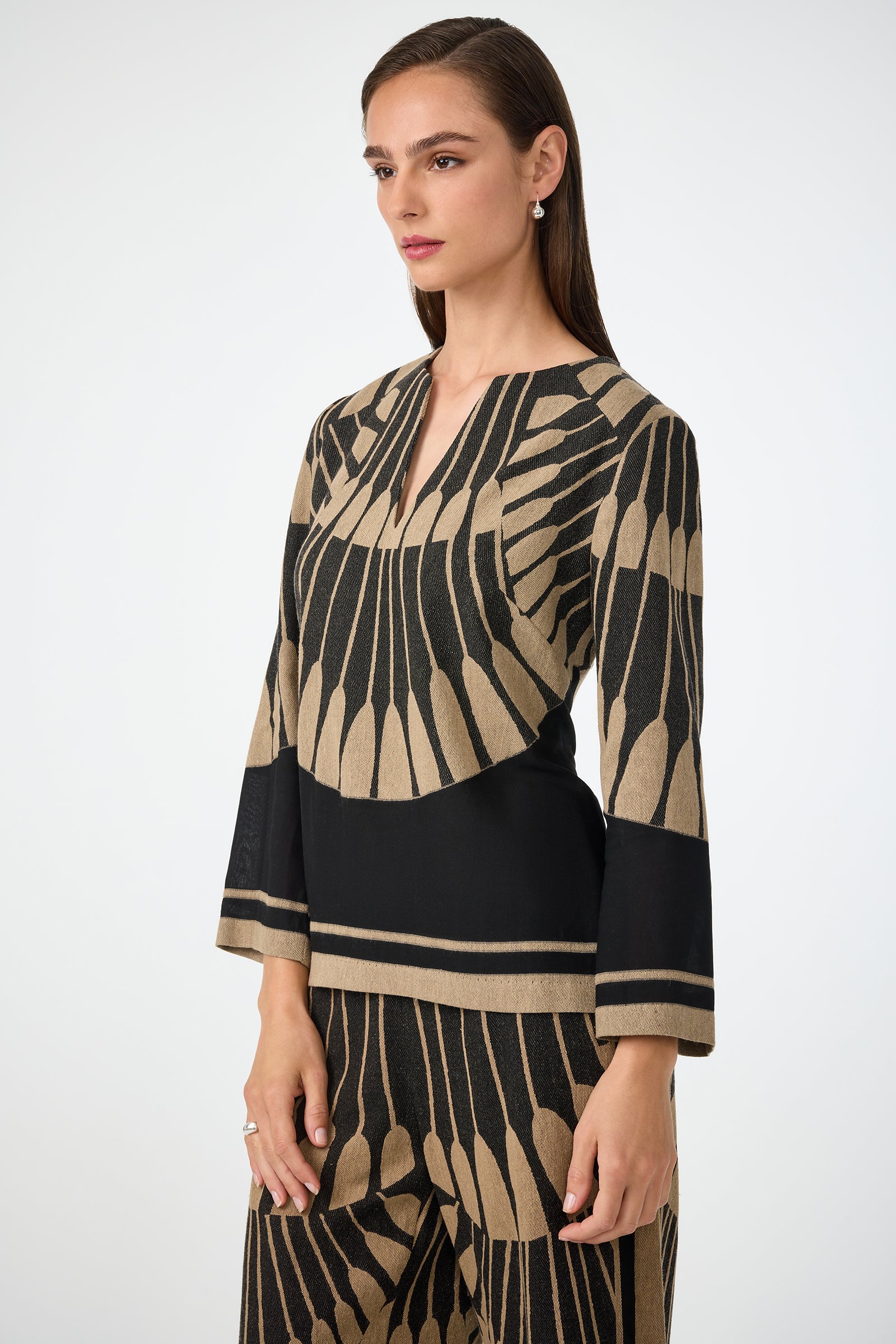 Woman with straight brown hair wears the Amy 3/4 Sleeve Top in Juniper Fil Coupe, paired with matching patterned pants, standing against a plain white background and looking slightly to the side.
