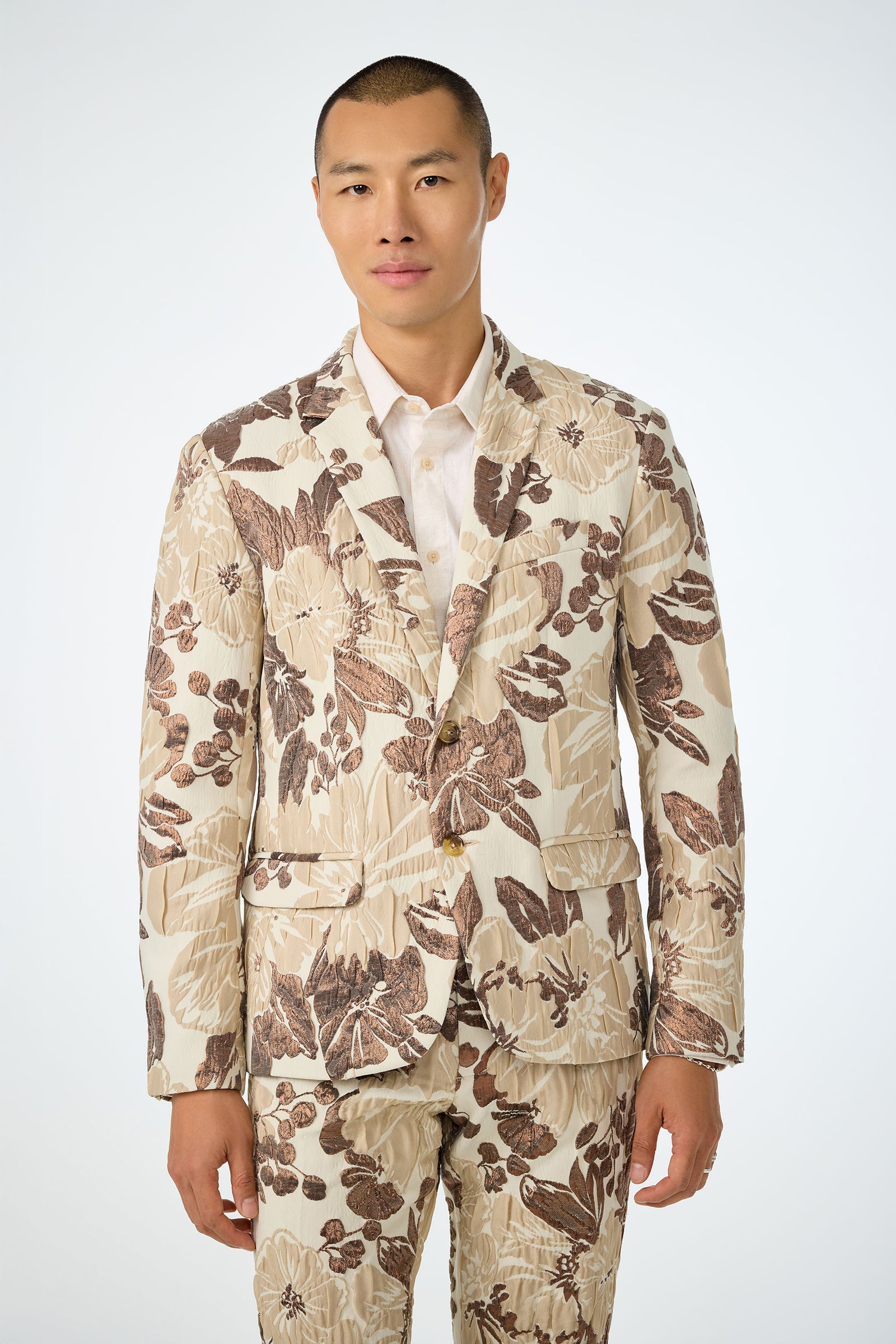 A person stands facing forward against a white background, wearing the Thurston Blazer in Daintree Jacquard over a white dress shirt.