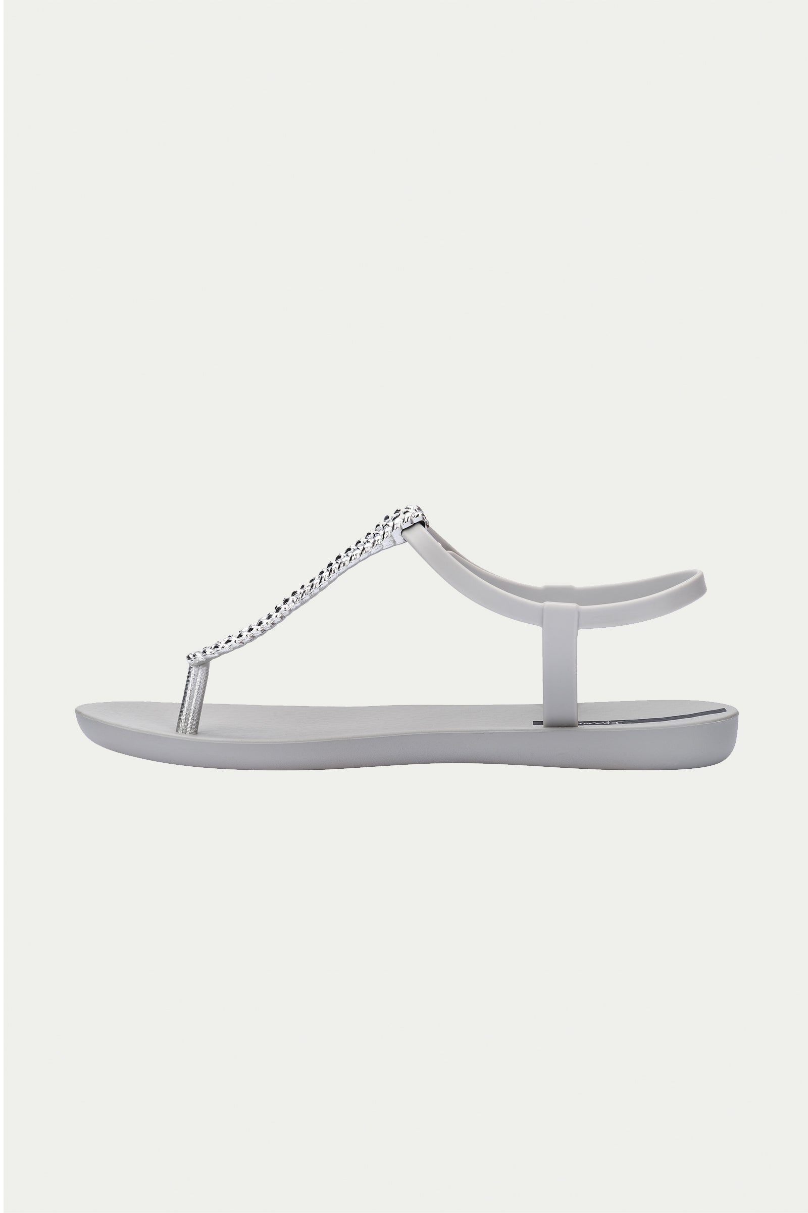 The Ipanema Class Twist Sandal in Grey is a minimalist flat sandal featuring a toe post, ankle strap, and a decorative silver chain detail across the top.