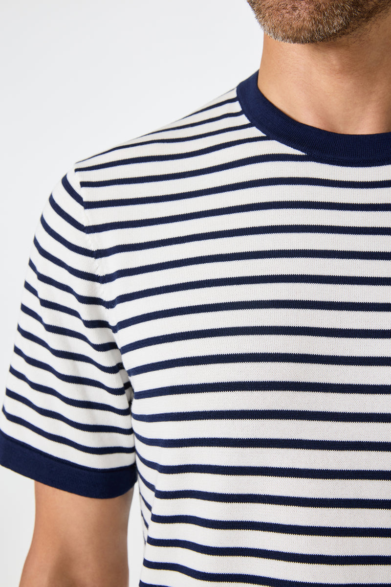 Close-up of a person wearing the Giovanni Stripe Short-Sleeve Pullover, featuring white fabric with horizontal navy stripes and navy trim on the collar and sleeve cuffs. Only the lower face and upper torso are visible.