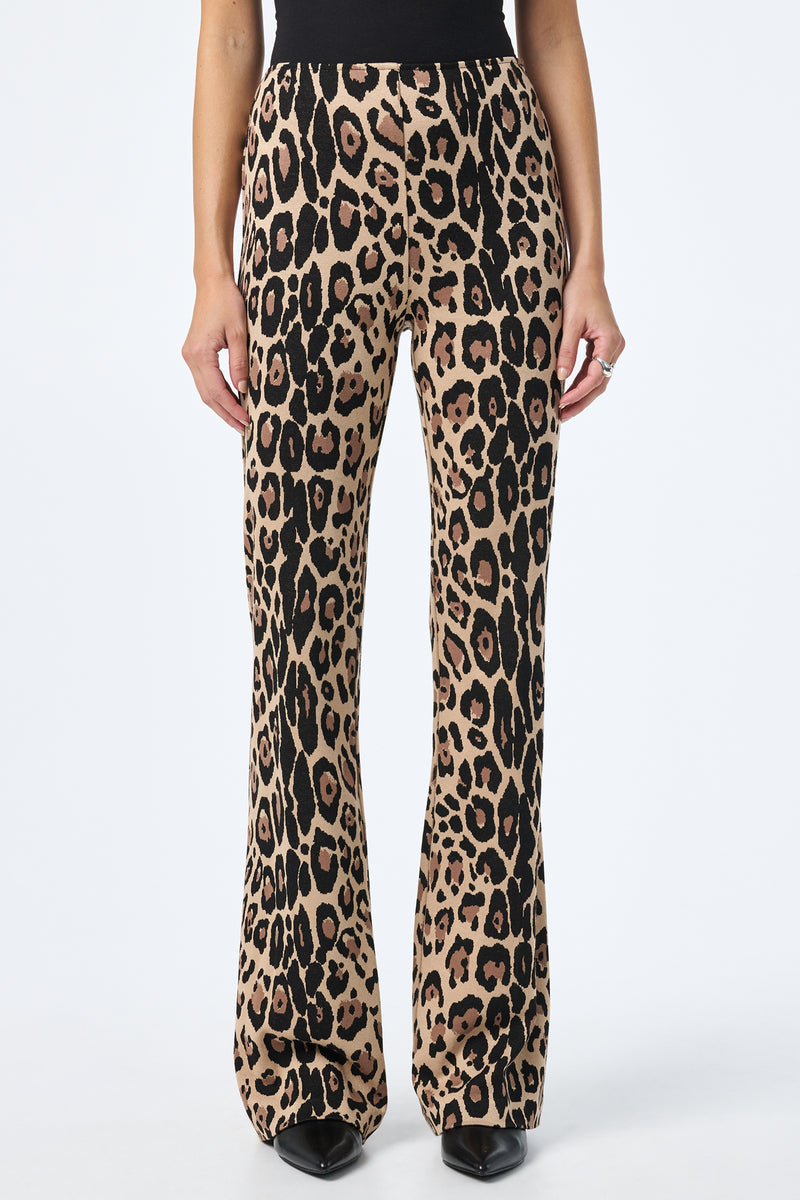 A person wearing Jacoba Slim-Fit Bootcut Pants stands against a white background, styled with black pointed-toe shoes.