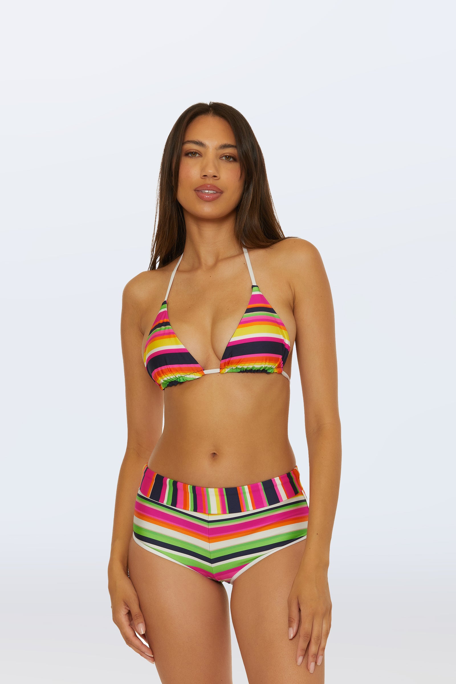 A woman with long brown hair wears the Boy Short Swim Bottom in Splash Stripe and a matching triangle bikini top, standing against a plain light background.